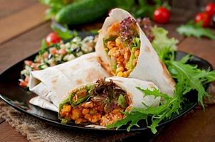 burritos envolve com carne picada e legumes em um fundo de madeira foto