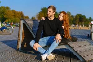 casal feliz cara e menina estão sentados em um deck de madeira abraçando foto