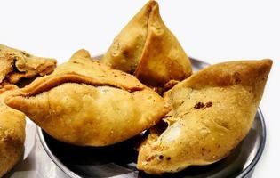 samosa de batata em fundo branco, comida tradicional indiana ou paquistanesa do ramadã foto