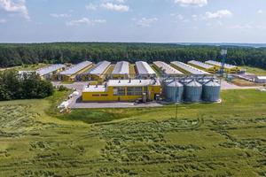 vista aérea em silos e complexo agro-pecuário em planta de agroprocessamento e fabricação com elevador moderno de celeiro. fazenda de frango. fileiras de galinheiro foto