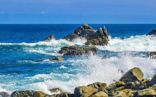 belas ondas de surfista rochas falésias na praia puerto escondido méxico. foto