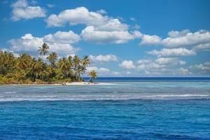 bela praia tropical com areia branca, palmeiras, mar turquesa contra o céu azul com nuvens em dia ensolarado de verão. fundo perfeito da paisagem da ilha para férias relaxantes. costa paradisíaca exótica foto