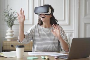 mulher espantada animada usando óculos vr desfrutando de uma incrível experiência de realidade virtual no trabalho foto