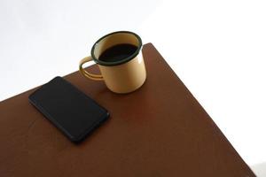 canecas de café amarelas e telefones na mesa de madeira dentro de casa. foto