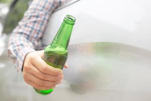 esta mulher come cerveja enquanto dirige, enfatiza a cerveja engarrafada. foto