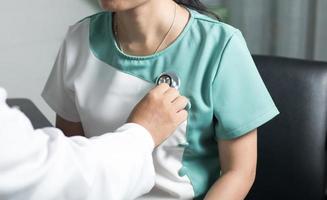 close-up de um médico ouvindo os batimentos cardíacos de um paciente foto