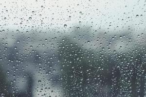 gotas de chuva na janela com fundo desfocado, dia chuvoso, gota de água no vidro, sentindo-se solitário conceito. foto