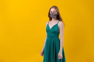 máscara de proteção de mulher jovem e bonita vestindo para doença de coronavírus em amarelo foto