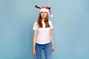 retrato de estúdio de jovem com cabelo comprido, vestindo um chapéu de Papai Noel foto