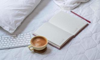 café com notebook e teclado na cama foto
