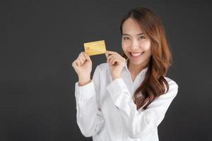 mulher de negócios vestindo camisa branca em pé segurando o cartão de crédito. foto