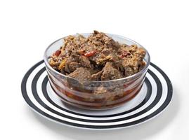 caril de carne tradicional servido em tigela transparente vista frontal no prato de cerâmica foto