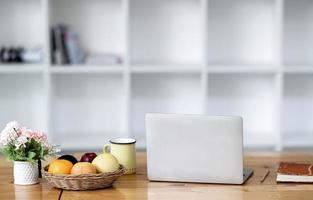 laptop com frutas e café em uma mesa