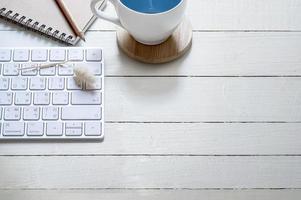 café e teclado em uma mesa de madeira foto