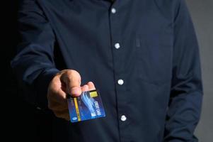 um empresário mostrando cartão de crédito foto