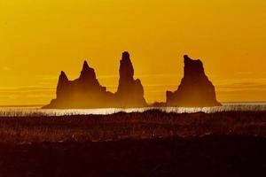 pôr do sol na praia de areia preta em vik, Islândia foto