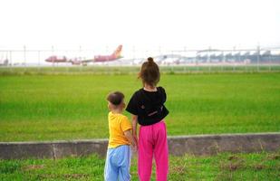 as crianças ficaram animadas e felizes ao ver os aviões decolando e pousando ao lado do aeroporto. foto