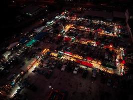 vista aérea no mercado noturno. há muitas pessoas, carros e lojas. foto