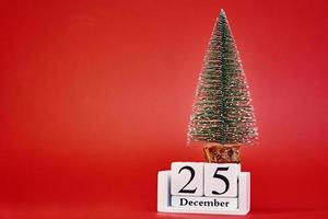 feliz natal e feliz ano novo composição com árvore de natal em fundo vermelho foto