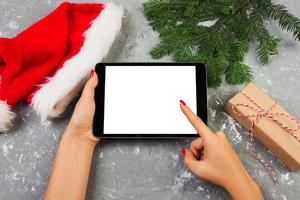 garota usando tecnologia tablet em casa, pessoa segurando computador na decoração de natal de fundo, mãos femininas enviando mensagens de texto, modelos de maquete foto