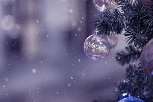 fundo de natal de uma árvore de natal decorada com brinquedos de ano novo na rua. neve, férias de inverno foto