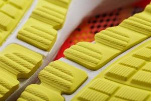 close-up da banda de rodagem de um tênis amarelo, o padrão texturizado da sola. foto