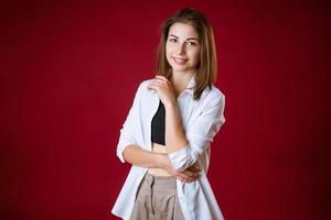 retrato de uma bela jovem posando em um fundo vermelho foto