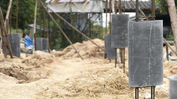 revestimento do tubo de cimento que cobre a estrutura de colunas da casa. construção de flutuante é baseado em ferro com base. imagem borrada do terreno alto do poço do pilar. foto