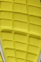 close-up da banda de rodagem de um tênis amarelo, o padrão texturizado da sola. foto