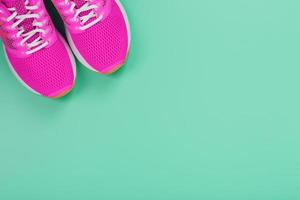 tênis esportivo rosa para correr em um fundo azul com espaço livre. foto
