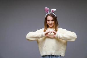 uma garota com orelhas de coelho em um fundo cinza foto