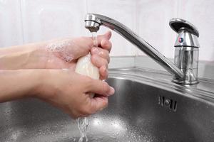 mulher lava as mãos com sabonete