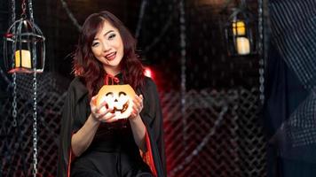 adolescente vestindo fantasia de bruxa para halloween segurando abóbora no tema halloween foto