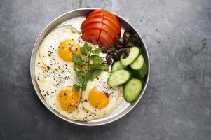 Apresentação de ovos cozidos com hortelã, tomate, azeitona, pepino e sumagre