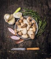 cogumelos crus com tomilho, alho fresco, cebola e faca vintage foto