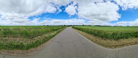 panorama de uma paisagem de país do norte da Europa com ruas, campos e grama verde. foto