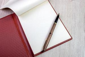 caderno aberto com páginas brancas e caneta-tinteiro de ouro foto