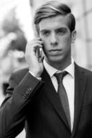 atraente jovem empresário ao telefone em meio urbano
