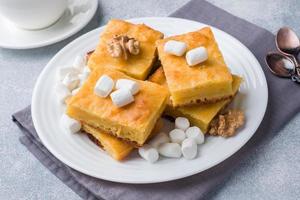 pedaços de torta de abóbora deliciosa com marshmallow e nozes em um prato. foto