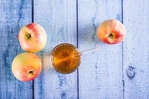suco de maçã fresco em um copo e frutas na mesa. bebidas caseiras. vista do topo foto