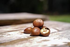 castanhas frescas isoladas em um piso de madeira, as castanhas têm um sabor doce oleoso. foto