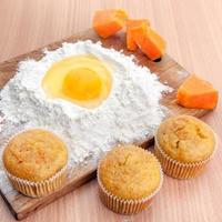 cupcakes, farinha e ovo na mesa da cozinha foto