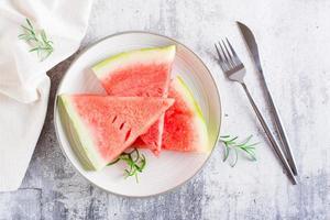 pedaços de melancia madura em um prato na mesa. refresco de verão. vista do topo foto