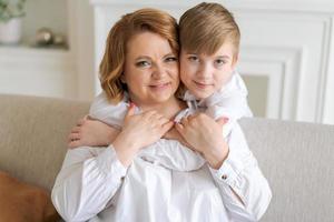 mulher feliz divirta-se com o bebê fofo 5-6-7 anos de idade na camisa branca. mamãe foto