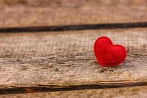um lindo coração vermelho encontra-se em um fundo de madeira foto