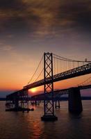 o sol se pondo atrás da ponte da baía de Chesapeake foto