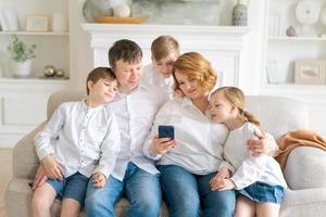 feliz alegre família caucasiana pai mãe e filhos se divertindo e usando digital foto