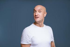 um homem adulto em uma camiseta branca sobre um fundo azul. foto