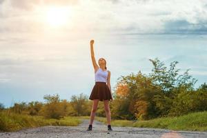 jovem de pé na estrada com a mão para cima, o conceito de sucesso. foto