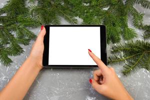 garota usando tecnologia tablet em casa, pessoa segurando computador na decoração de natal de fundo, mãos femininas enviando mensagens de texto, modelos de maquete foto